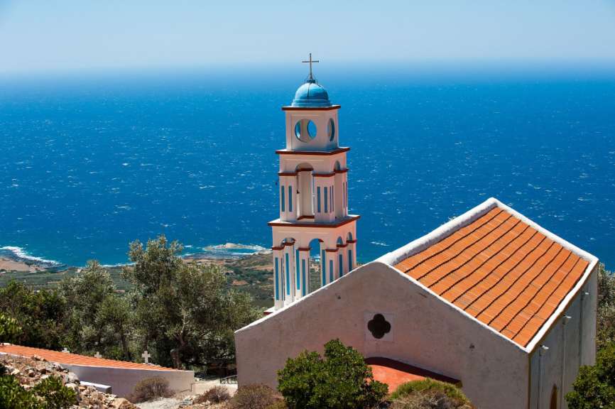 Eine weiße Kirche mit einem blauen Kreuz auf dem Turm