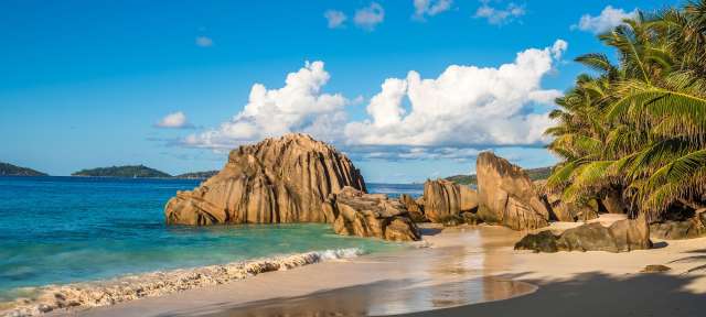 Tropischer Strand auf La Digue Ein Strand mit einem großen Felsen in der Mitte