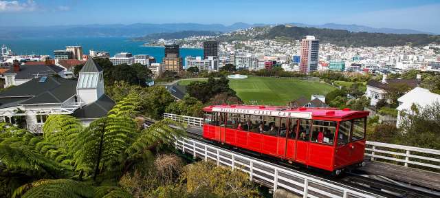 Wellington Eine rote Straßenbahn fährt durch eine Stadt