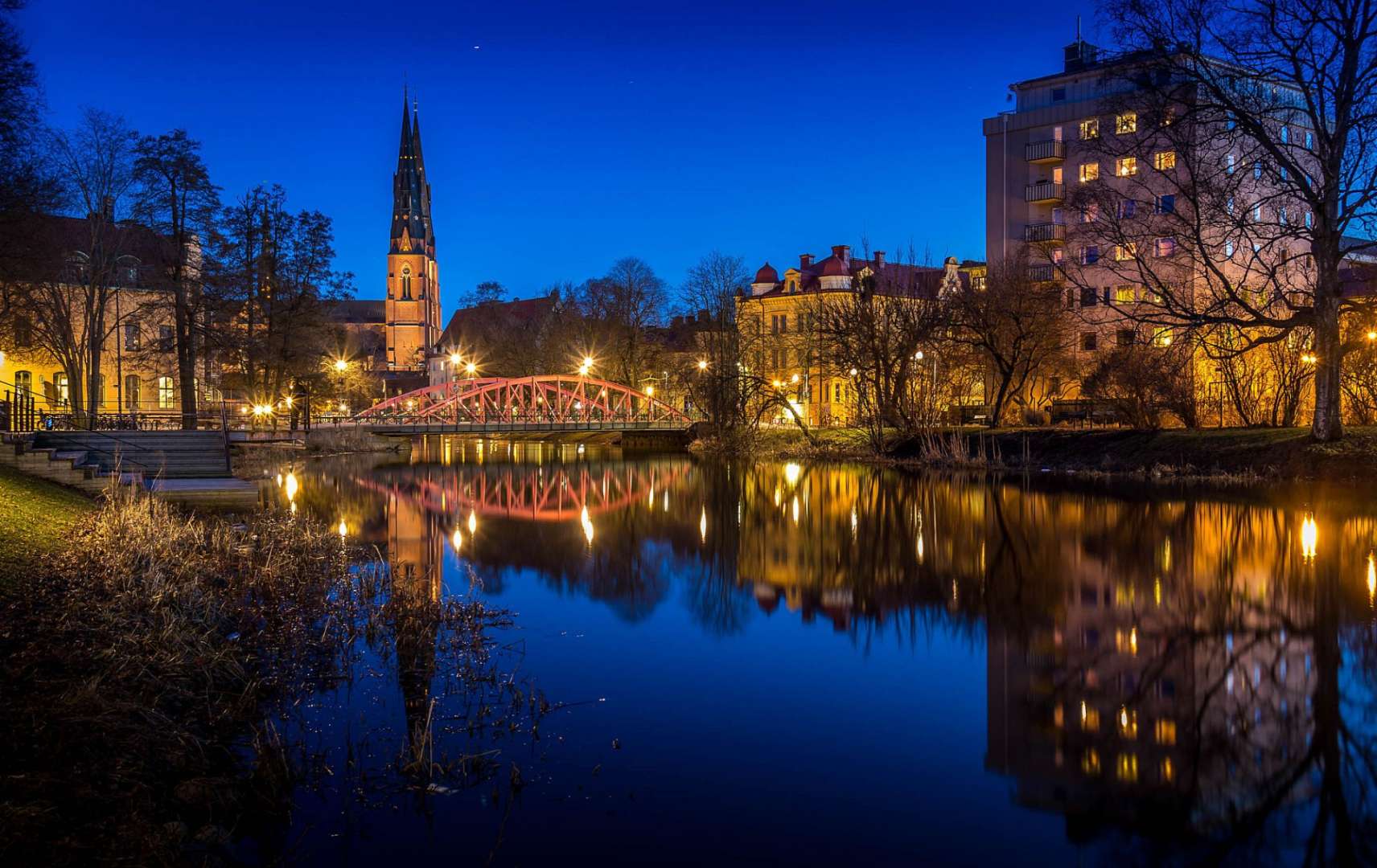 Eine Brücke über einen Fluss mit einer Kirche im Hintergrund