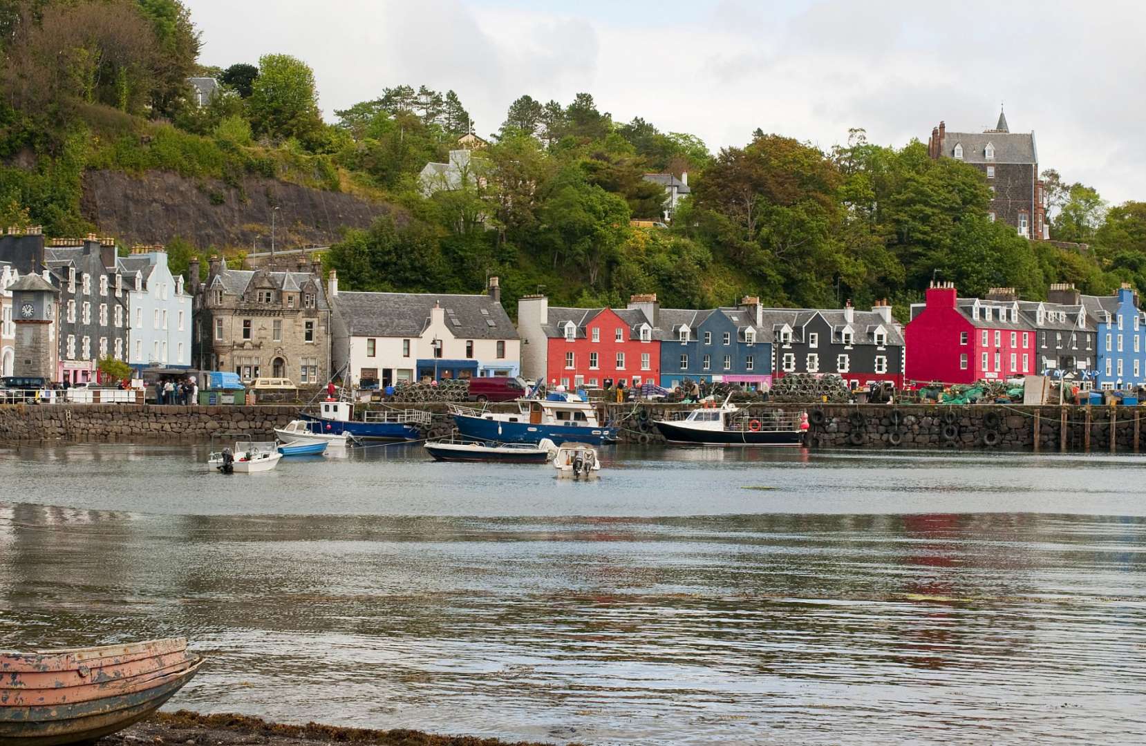 Ein Boot schwimmt in einem Hafen mit bunten Häusern im Hintergrund