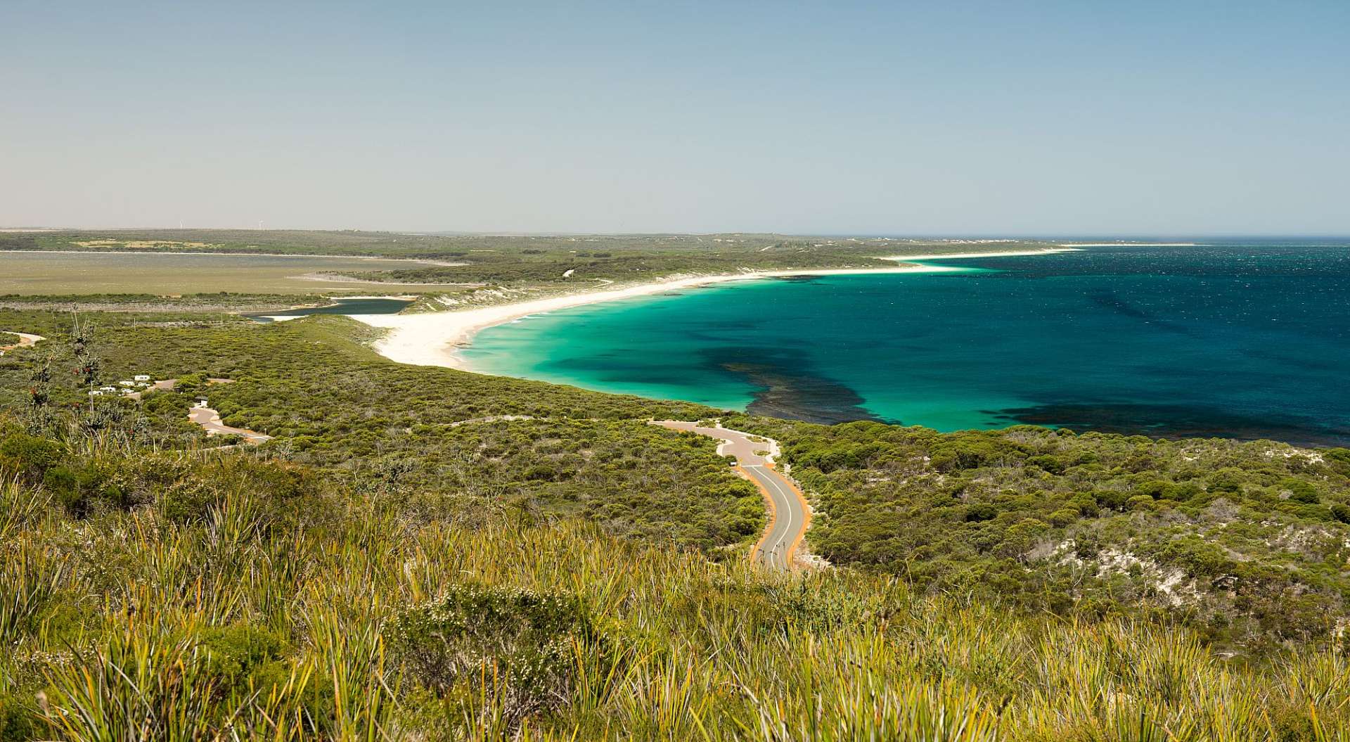 Eine Straße führt an einem Strand ins Meer