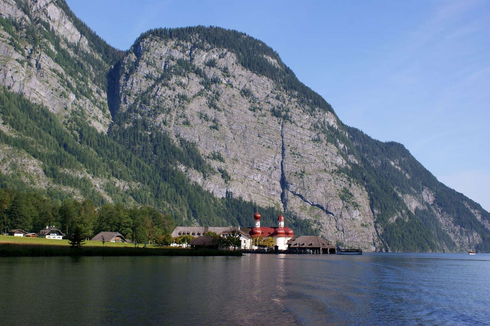 Eine Kirche steht am Ufer eines Sees inmitten einer Bergkette
