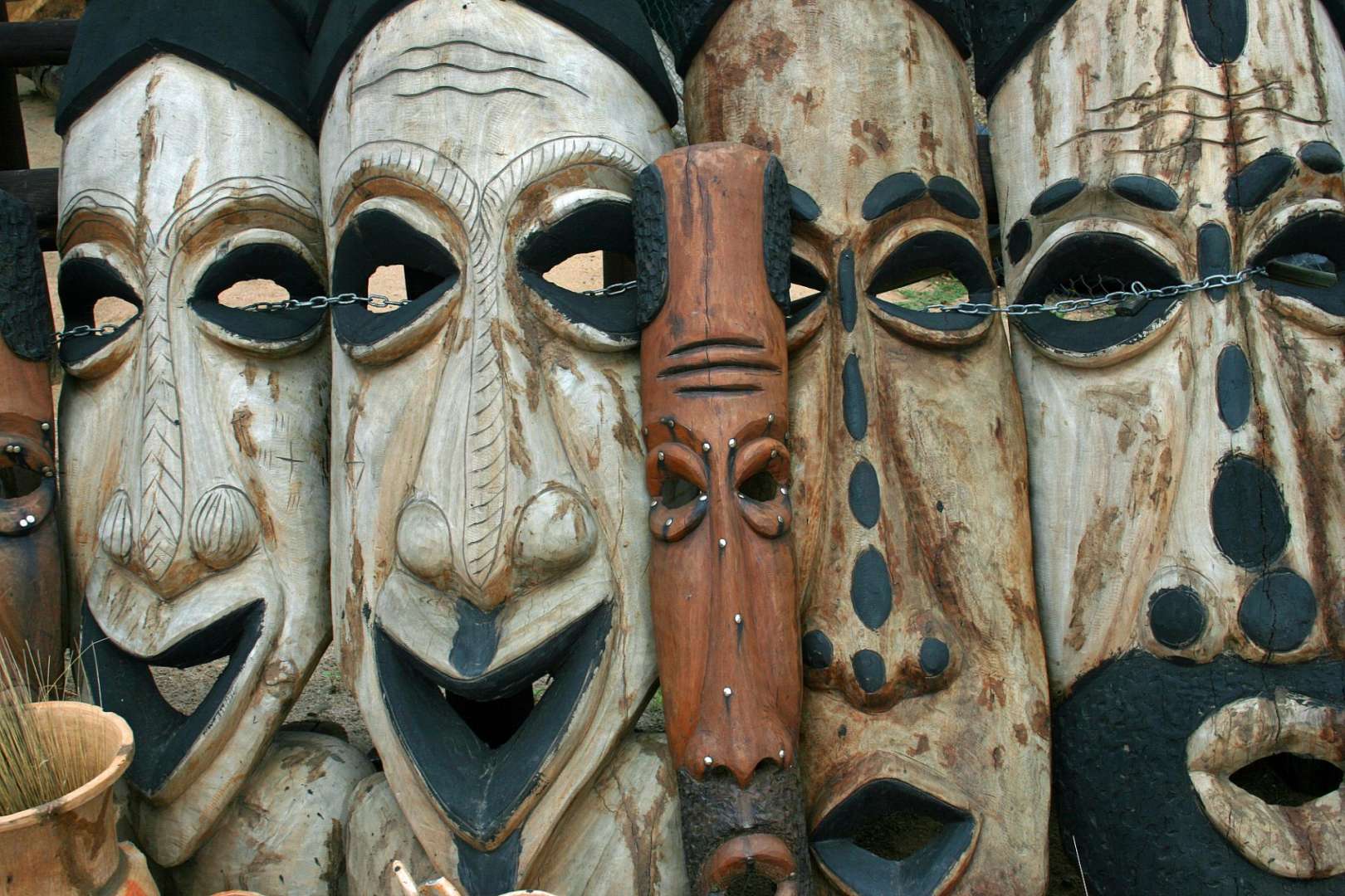 Eine Reihe von Holzmasken steht nebeneinander