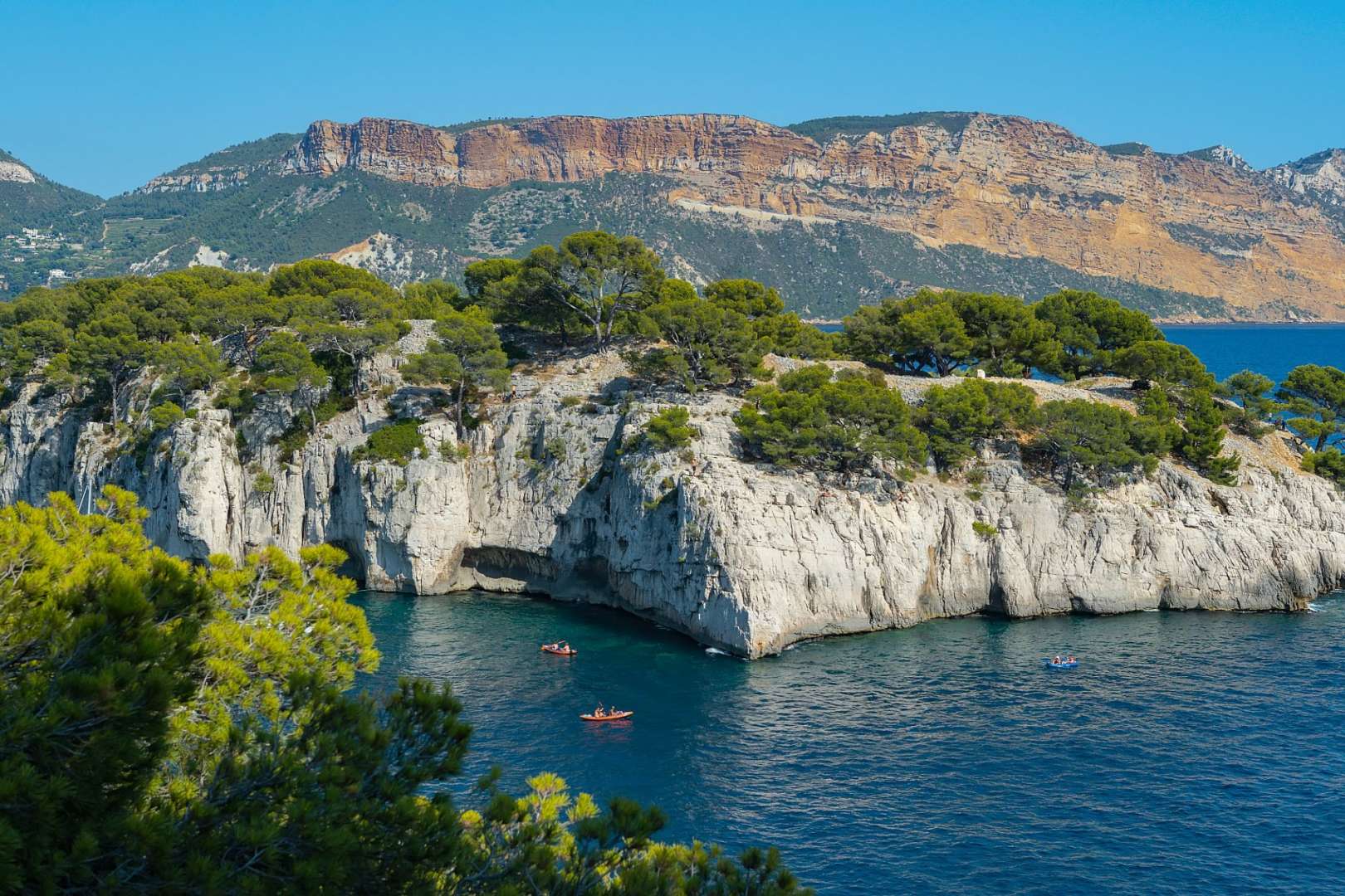 Ein paar Boote schwimmen in der Nähe einer Klippe im Ozean
