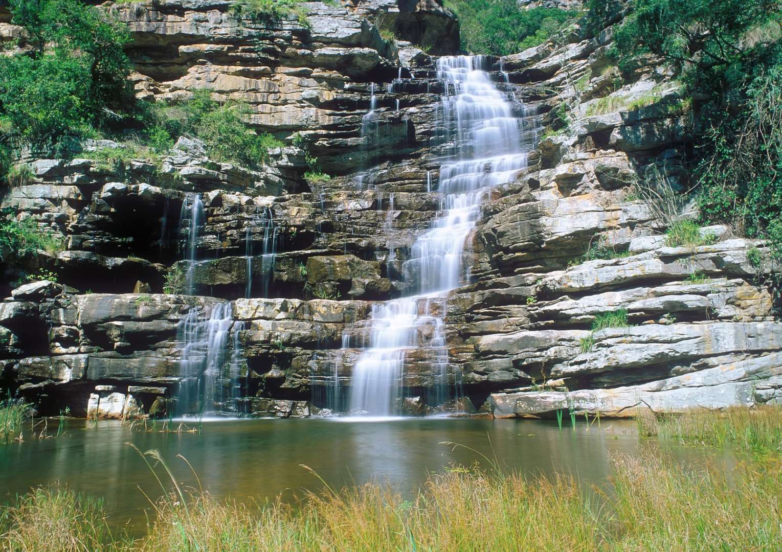 Ein Wasserfall stürzt in einen kleinen Teich