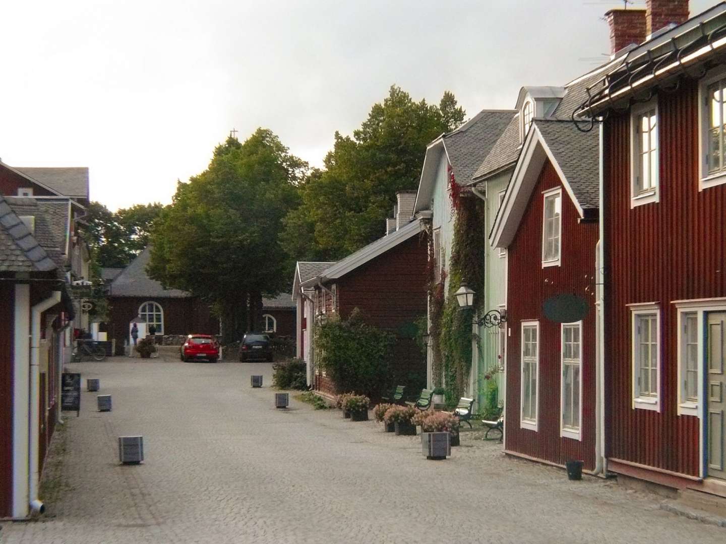 Eine Straße mit roten und grünen Häusern und einem roten Auto