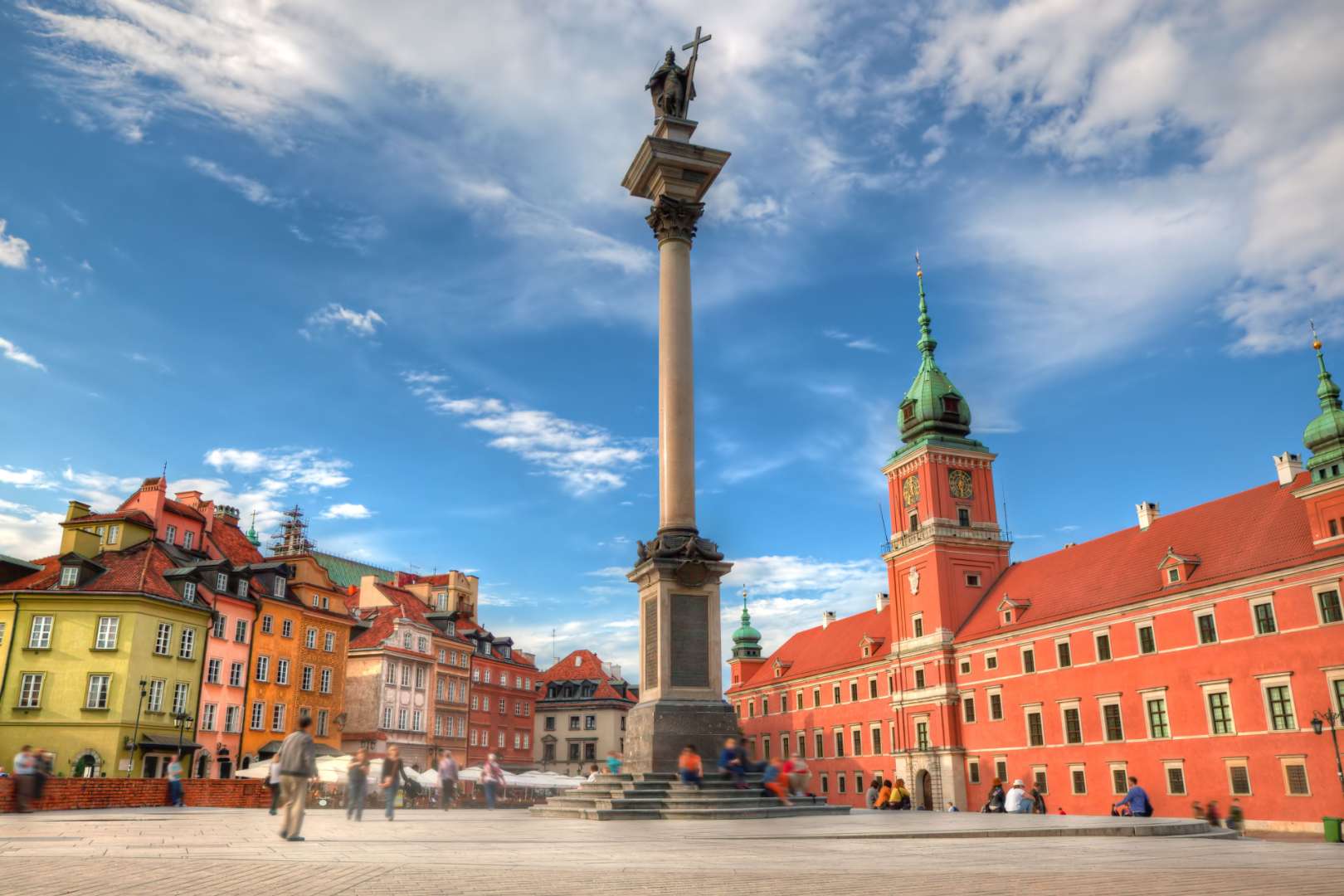 Eine Statue eines Mannes mit einem Kreuz auf einem Säulen vor einem Gebäude