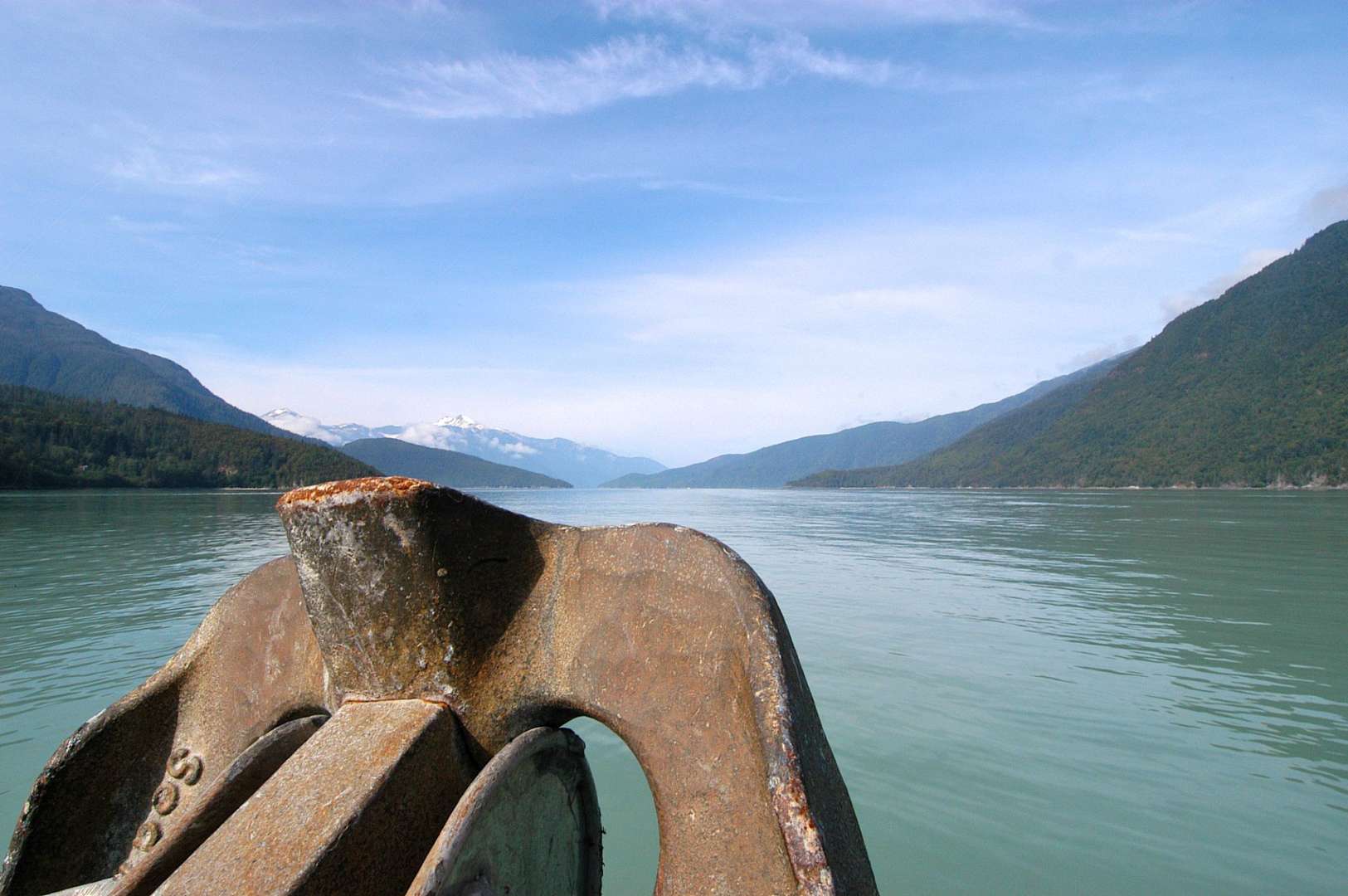 Ein Anker steht in einem See mit Bergen im Hintergrund