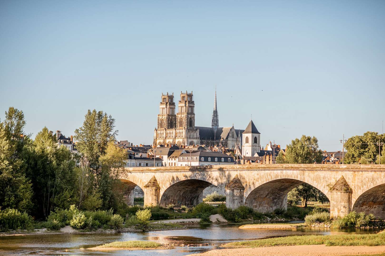 Eine Brücke über einen Fluss mit einer Kathedrale im Hintergrund