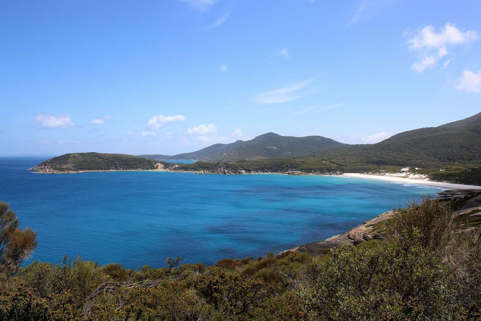 Ein großer blauer Ozean mit Bergen im Hintergrund