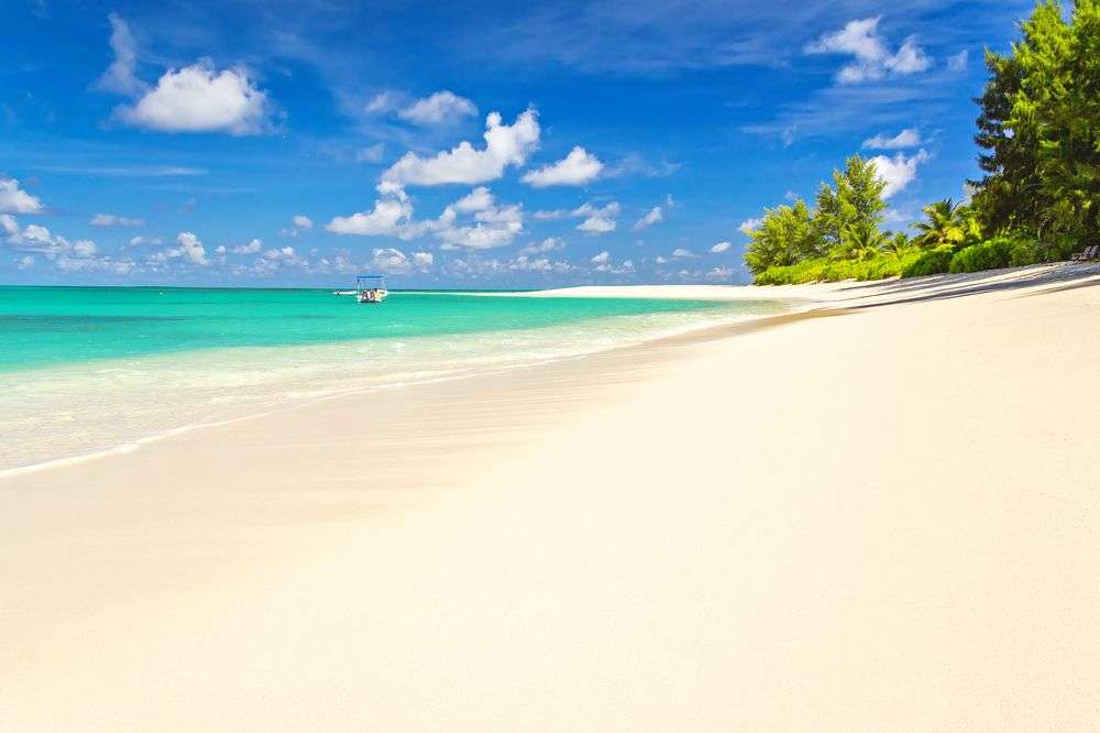 Ein weißer Sandstrand mit einem kleinen Boot im Ozean