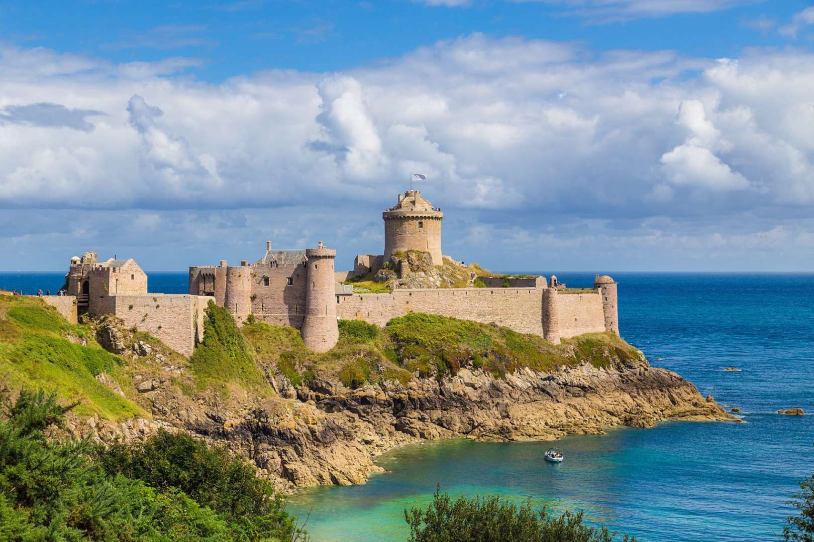 Ein großes mittelalterliches Schloss sitzt auf einer Klippe über dem Ozean