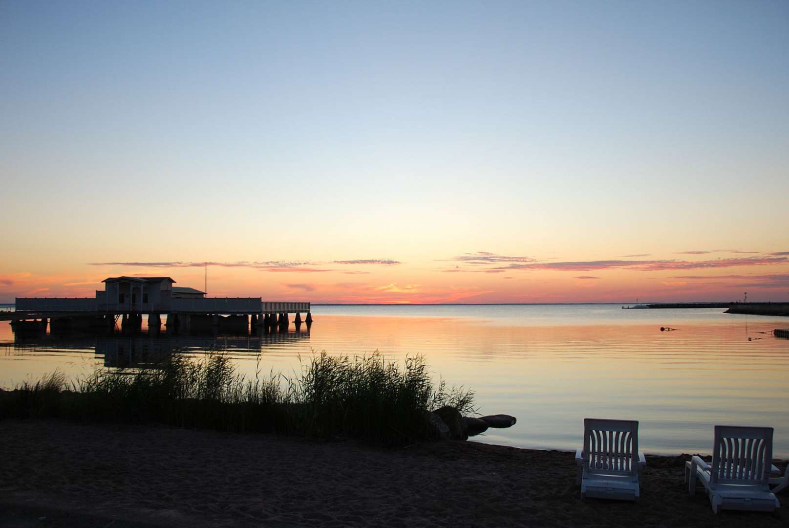 Ein Sonnenuntergang über einem See mit einem Gebäude im Hintergrund