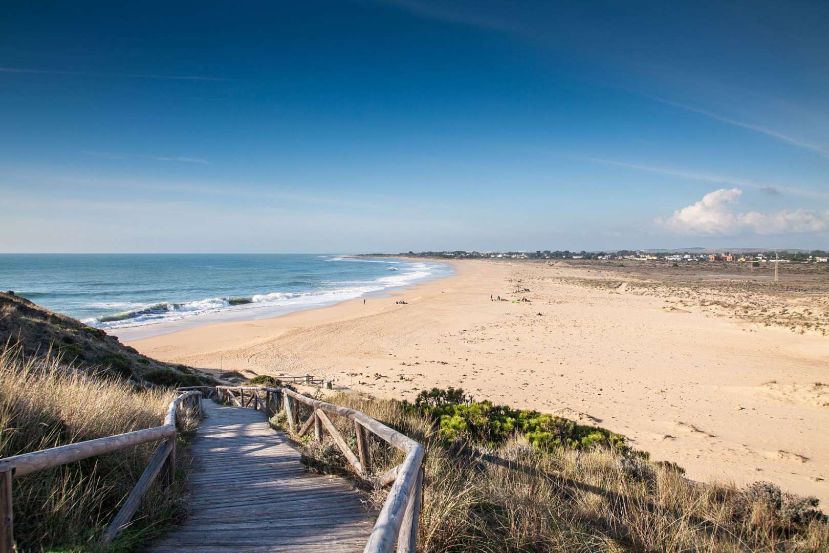 Eine Holztreppe führt hinunter zu einem Strand
