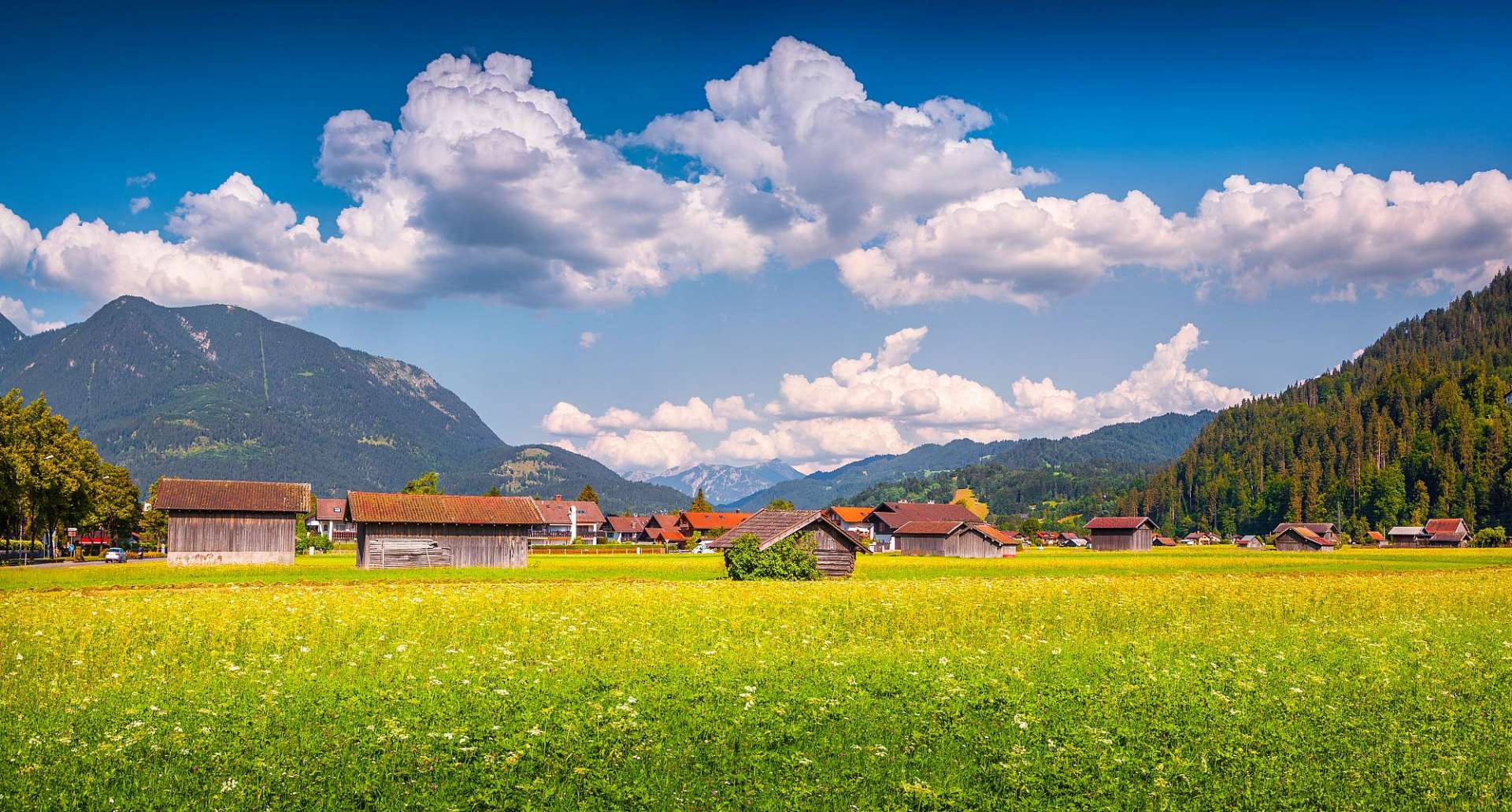 Ein Feld mit Hütten und Bergen im Hintergrund