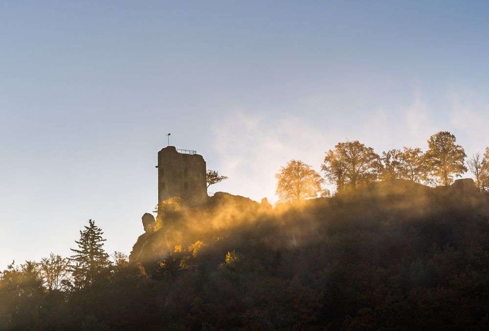 Ein Turm auf einem Hügel mit Bäumen davor