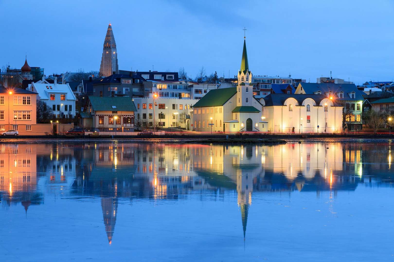 Eine Stadt mit vielen Gebäuden und einer Kirche spiegelt sich im Wasser