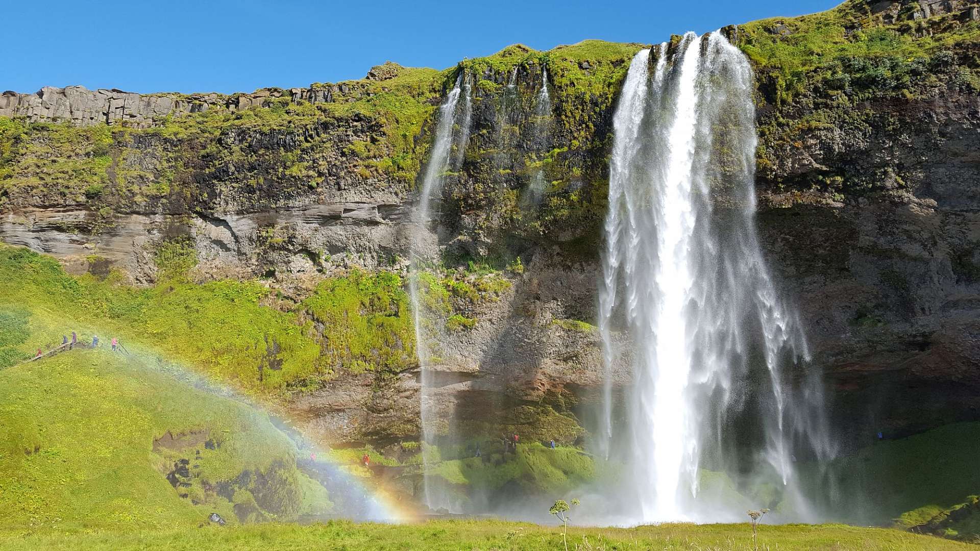 Ein Wasserfall mit einem Regenbogen dahinter