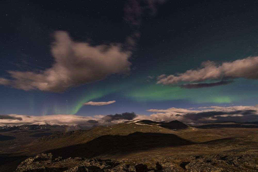 Das Nordlicht scheint über einem Berggipfel