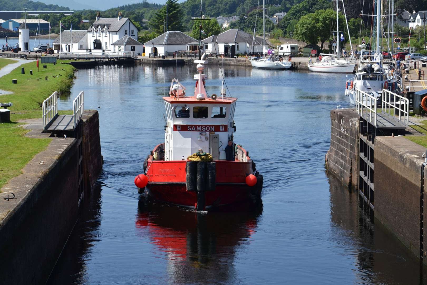 Ein rotes Boot mit der Aufschrift samson fährt durch eine Schleuse