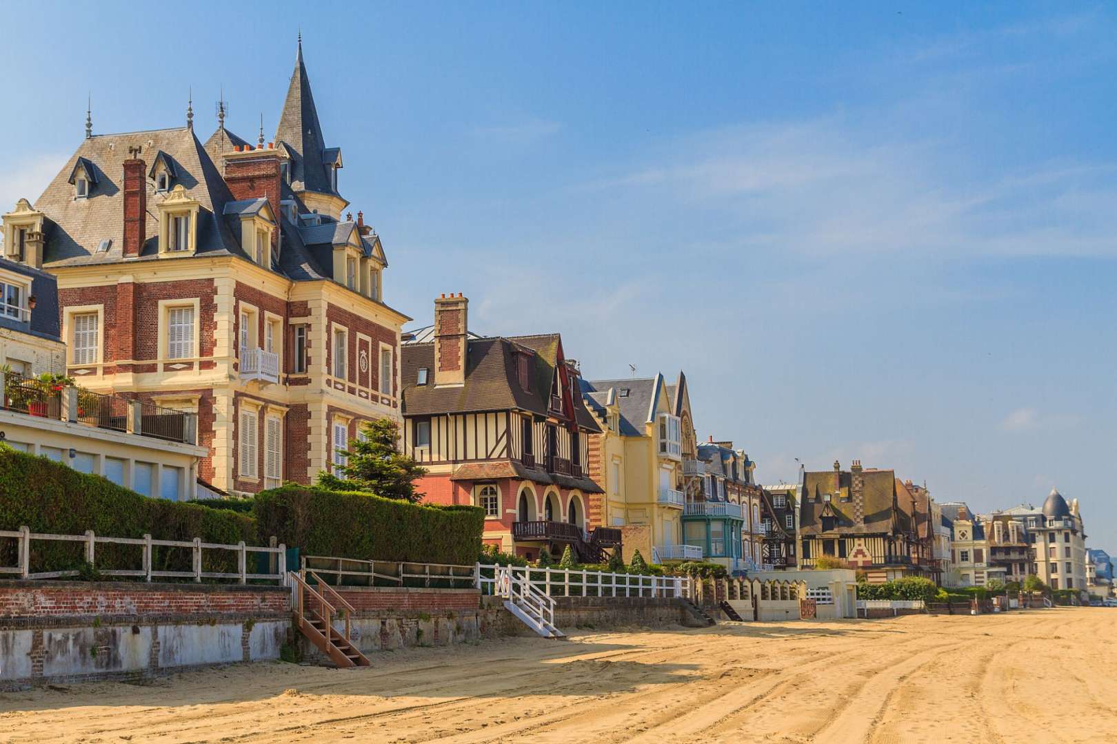 Eine Reihe von Häusern an einem Strand mit einem roten Haus davor