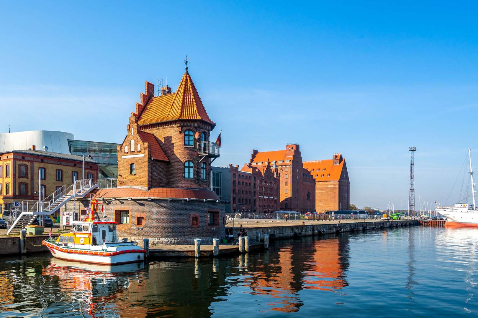 Ein rot-weißes Boot sitzt vor einem roten Backsteingebäude