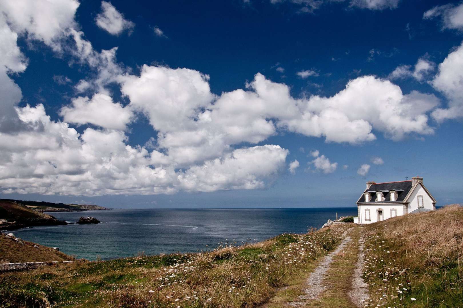 Ein weißes Haus auf einem Hügel mit Blick auf das Meer