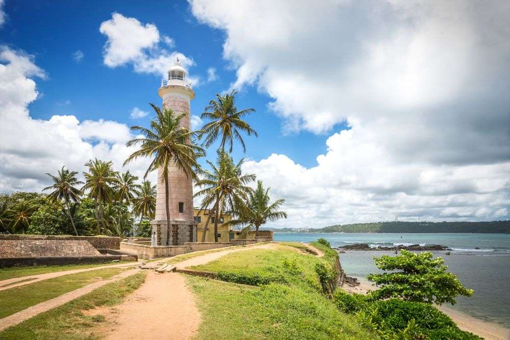 Ein Leuchtturm steht auf einem Hügel mit Blick auf das Meer