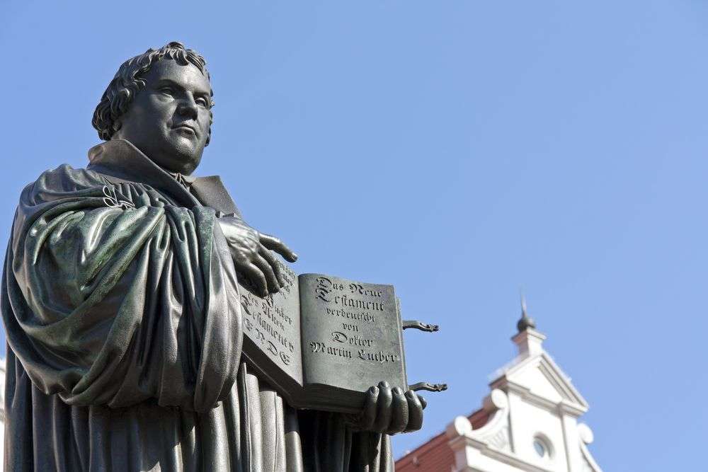 Eine Statue eines Mannes, der ein Buch in der Hand hält