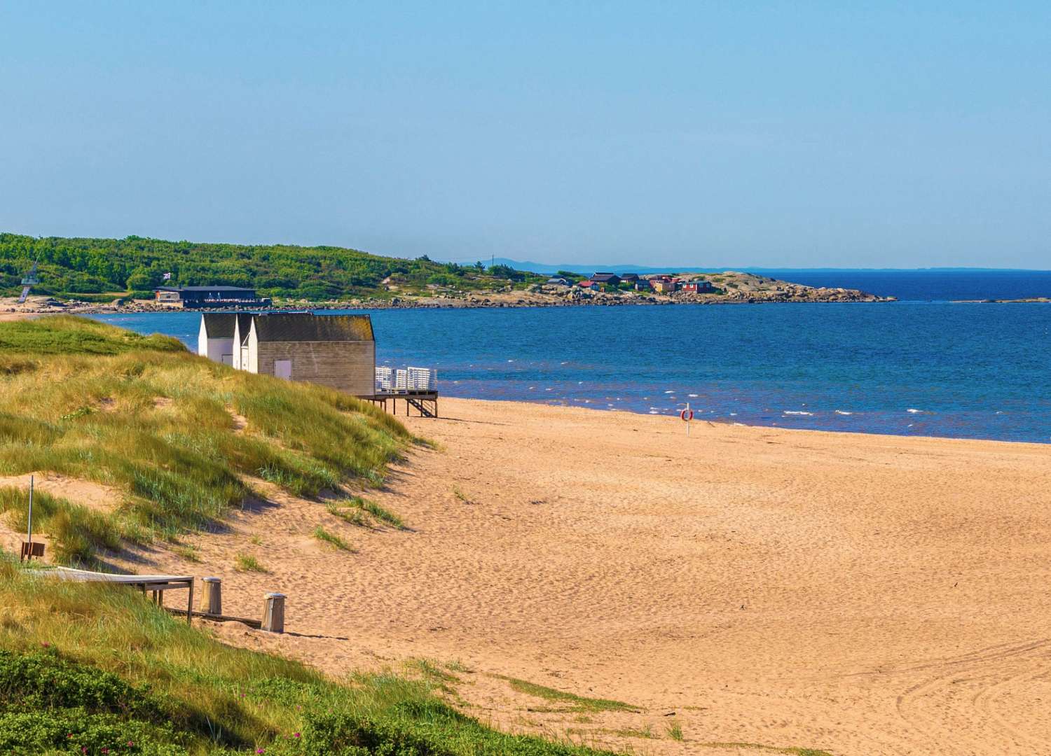 Ein Strand mit einem kleinen Gebäude in der Ferne