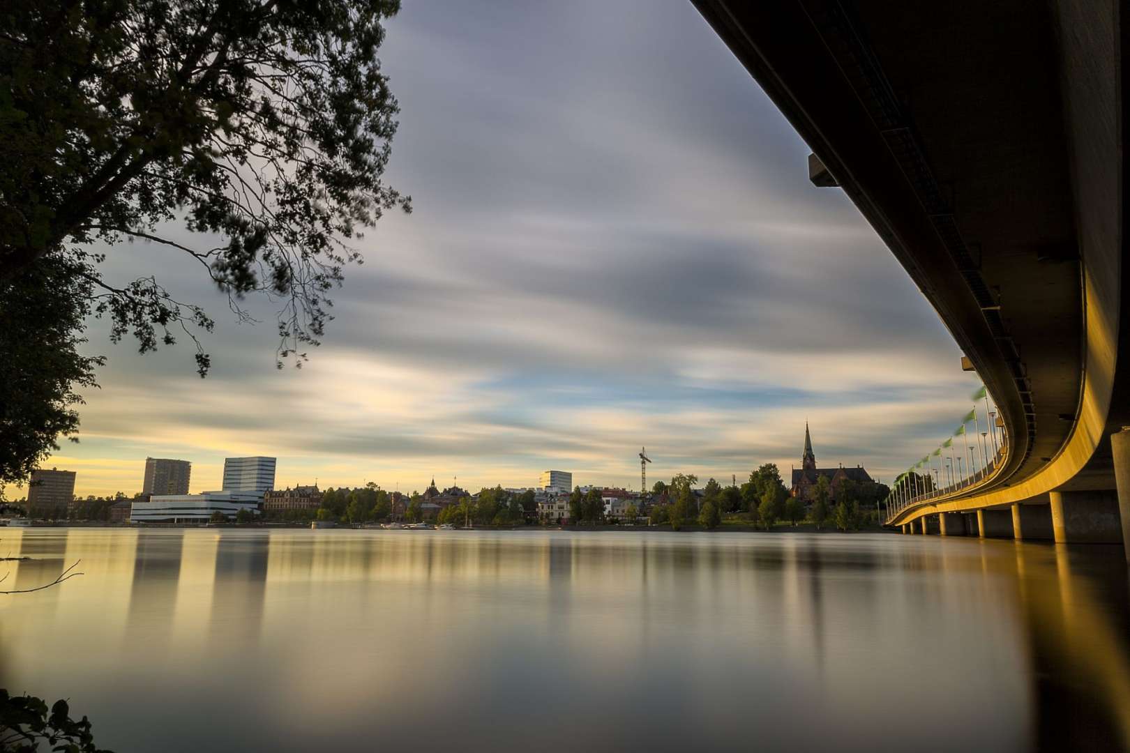 Eine Brücke über einen See mit einer Stadt im Hintergrund