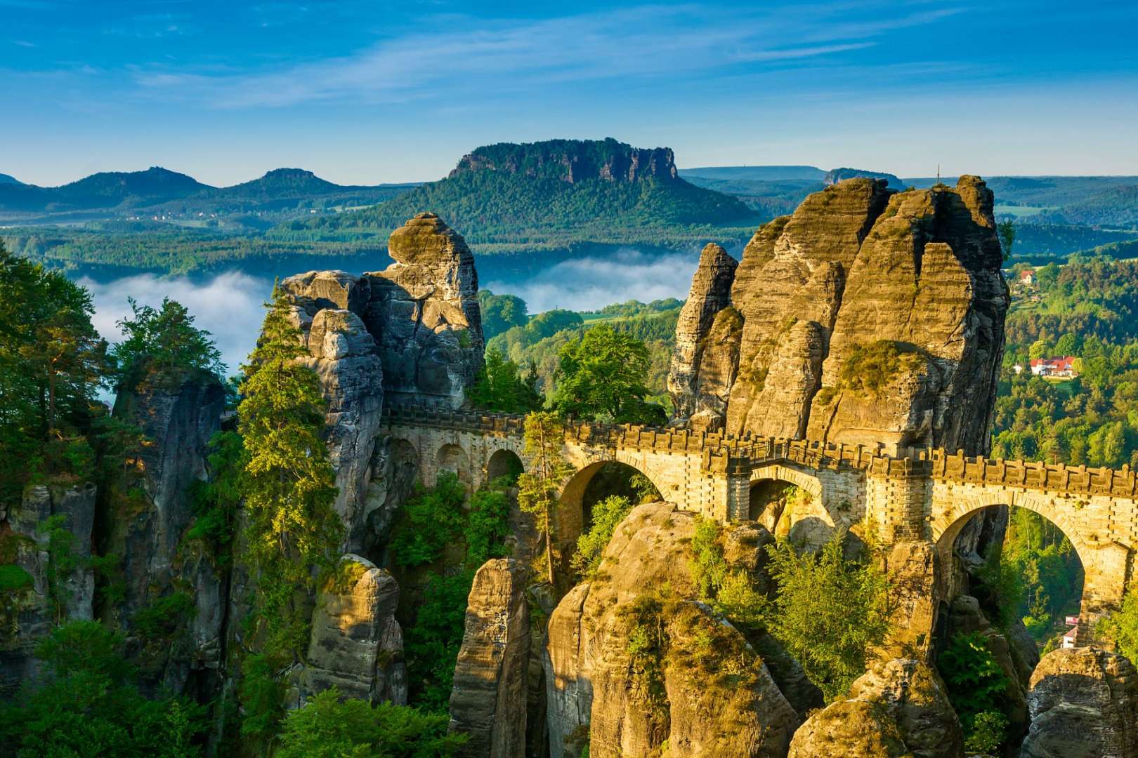 Eine Brücke führt zwischen zwei Felsen in einem Tal