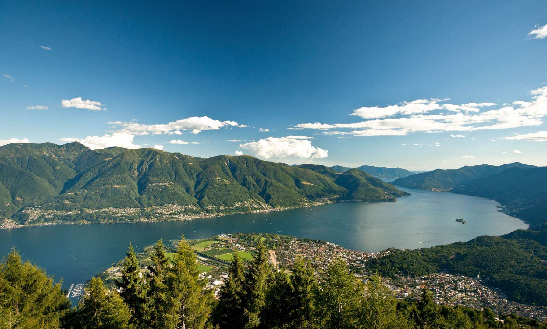 Ein großer See umgeben von Bergen und Bäumen