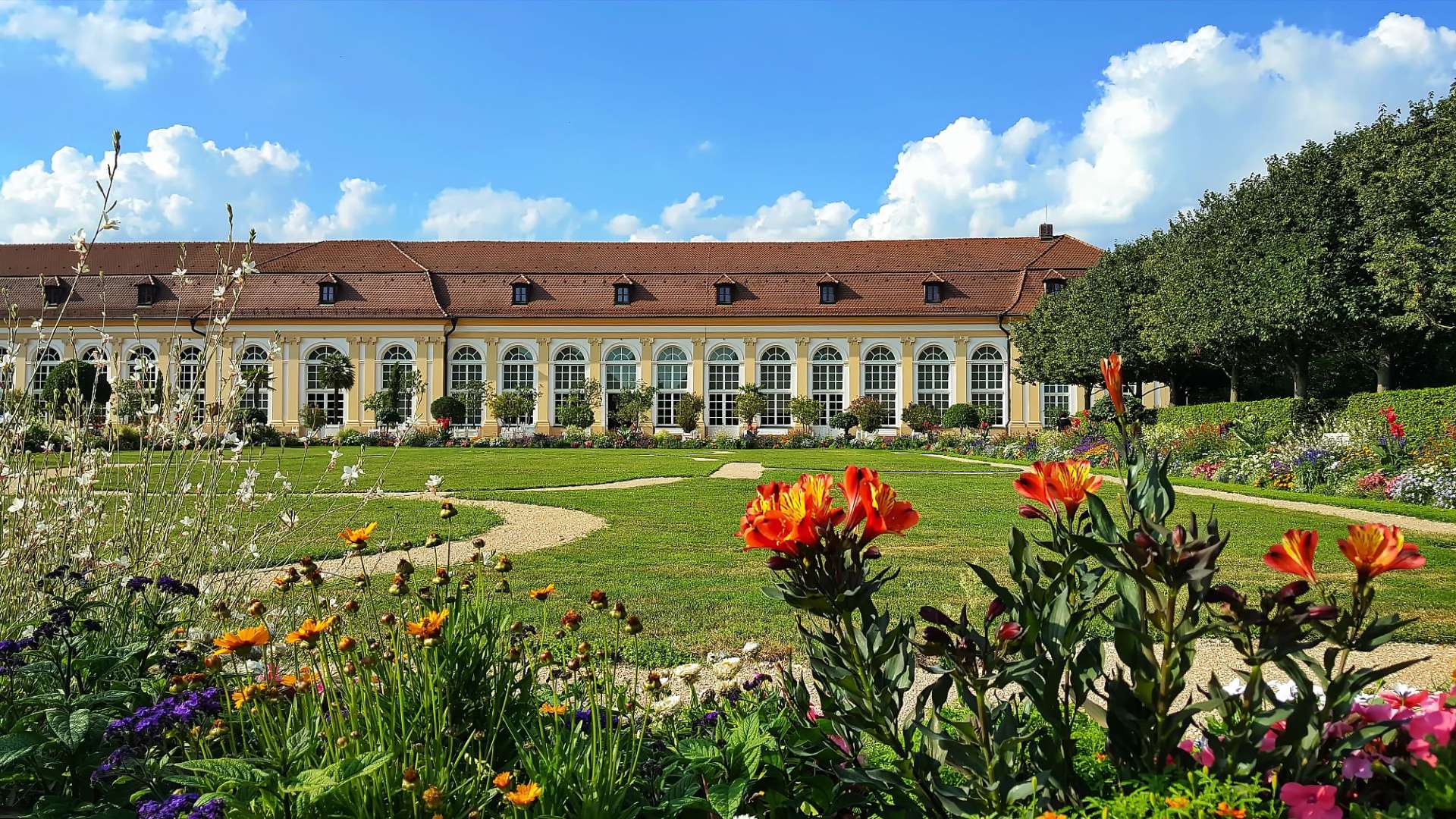 Ein großes Gebäude mit vielen Fenstern in einem Garten
