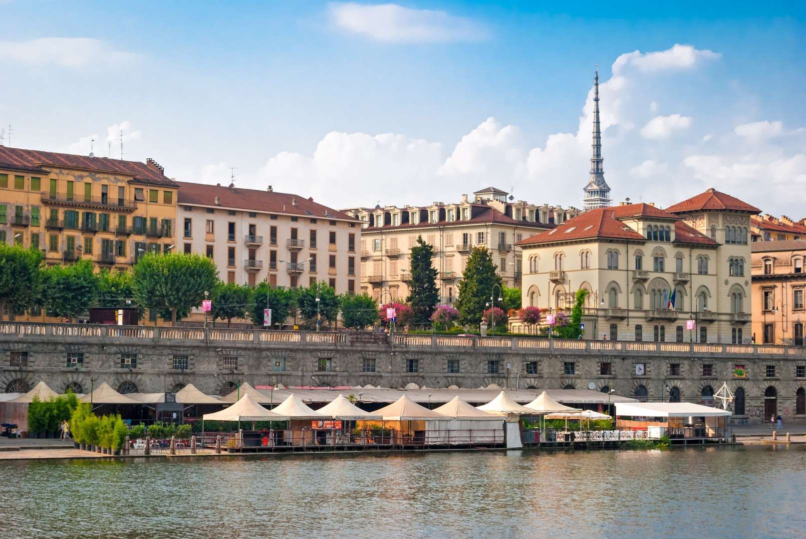 Eine Reihe von Gebäuden steht neben einem Fluss