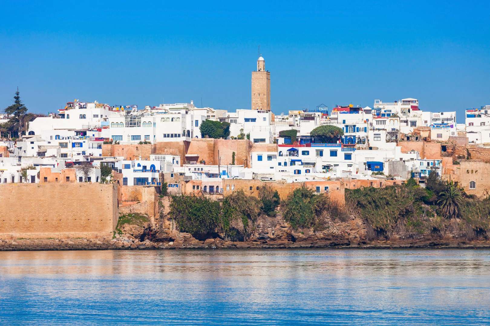 Eine Stadt mit weißen Gebäuden und einem Minarett über dem Wasser