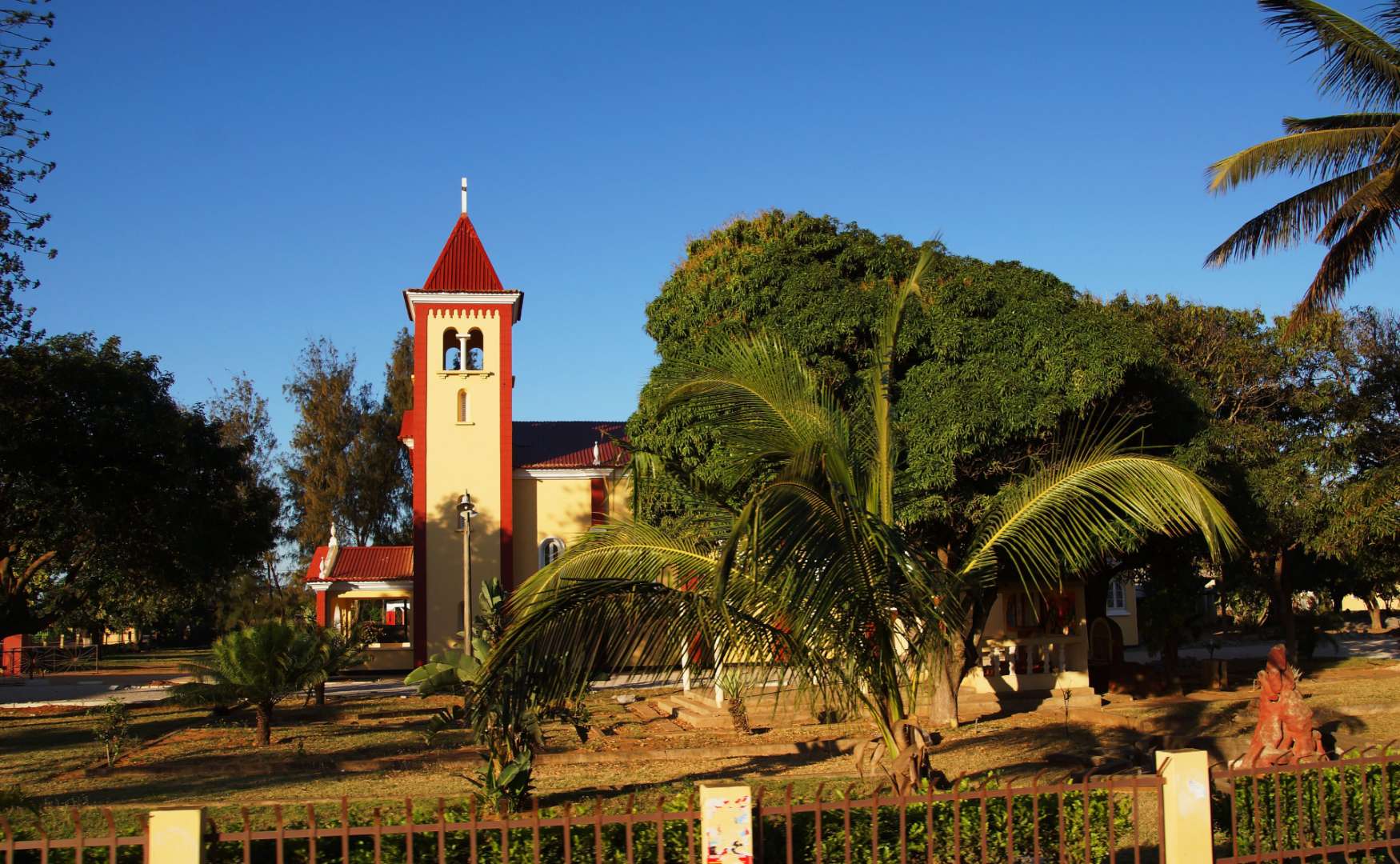 Eine Kirche mit einem roten Turm und einem weißen Kreuz darauf