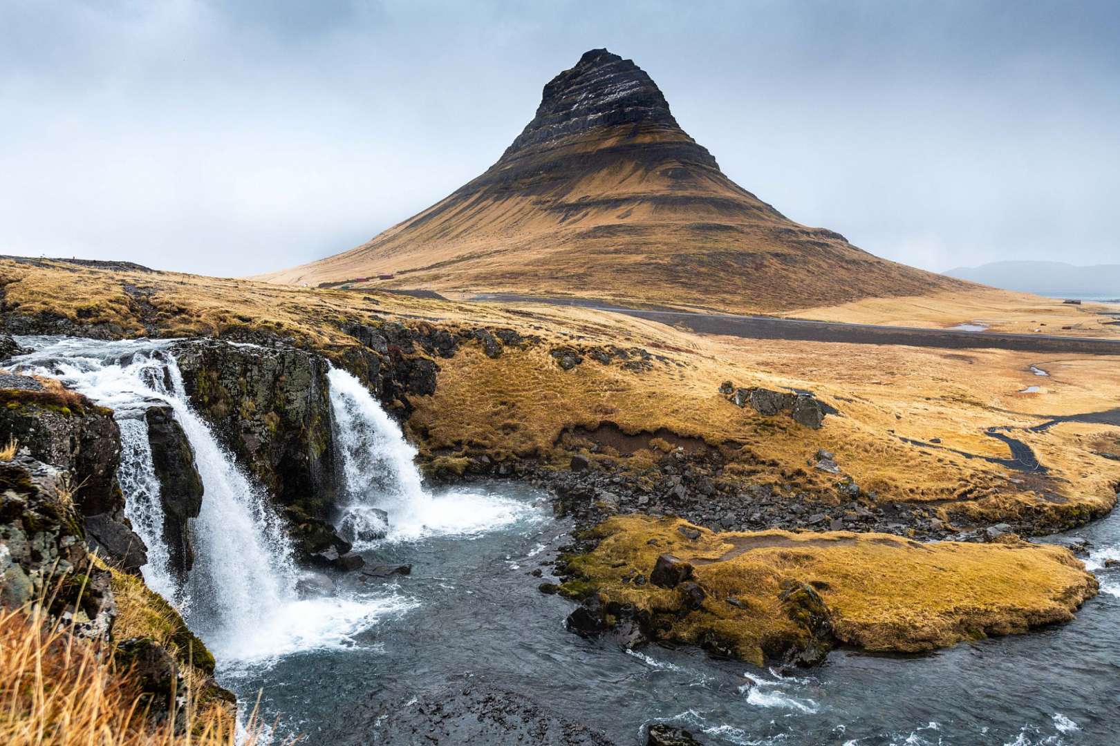 Ein Wasserfall mit einem Berg im Hintergrund
