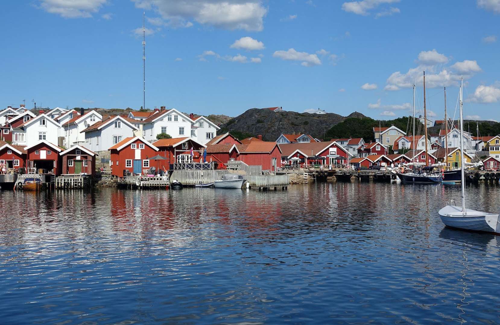 Ein kleiner Hafen mit roten Hütten und weißen Häusern