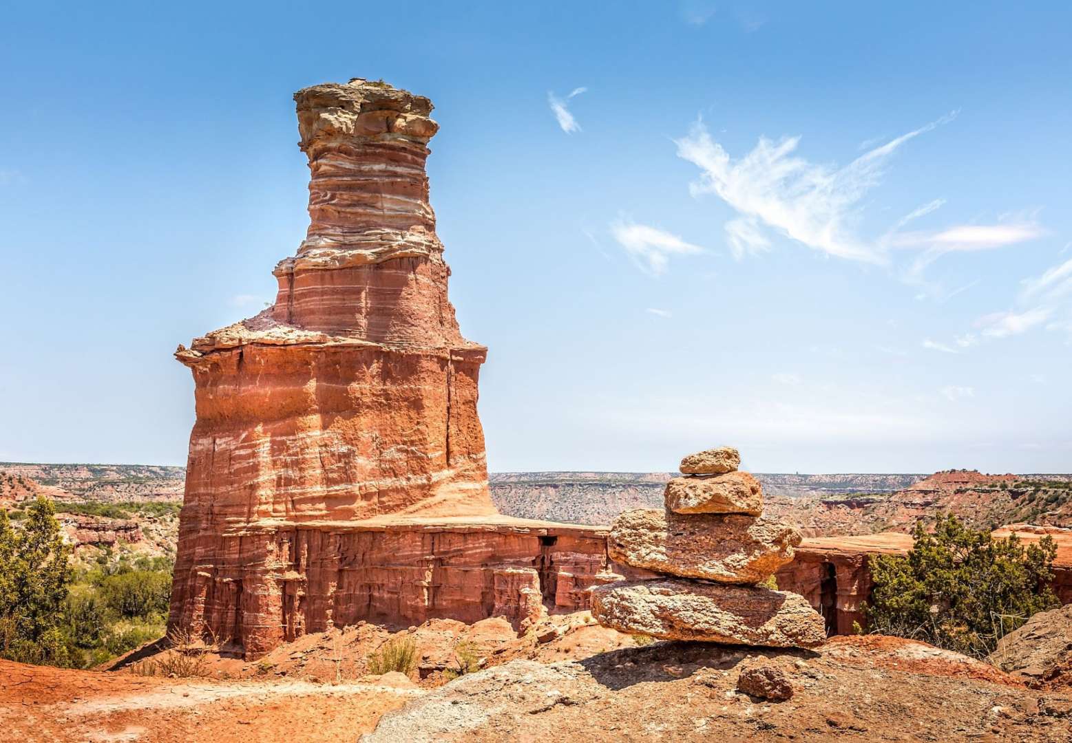 Eine Felsformation in der Wüste mit einem Turm dahinter