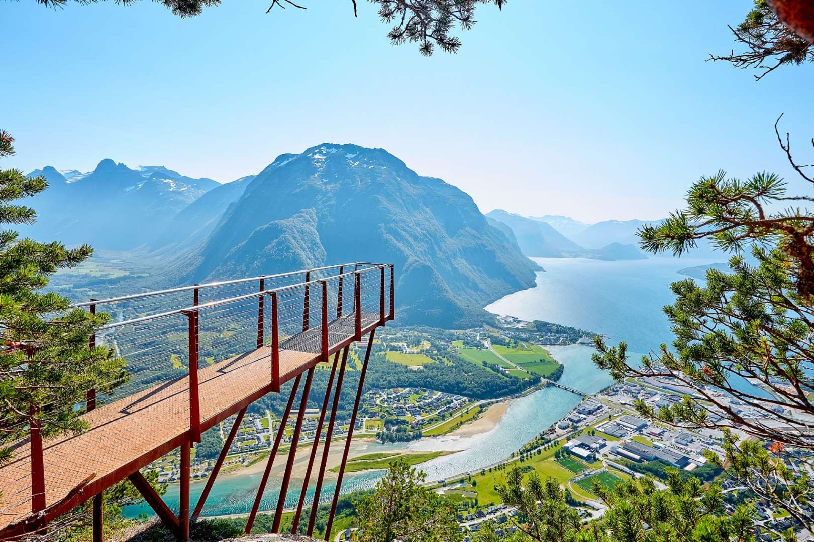 Eine Brücke mit Blick auf einen See mit Bergen im Hintergrund