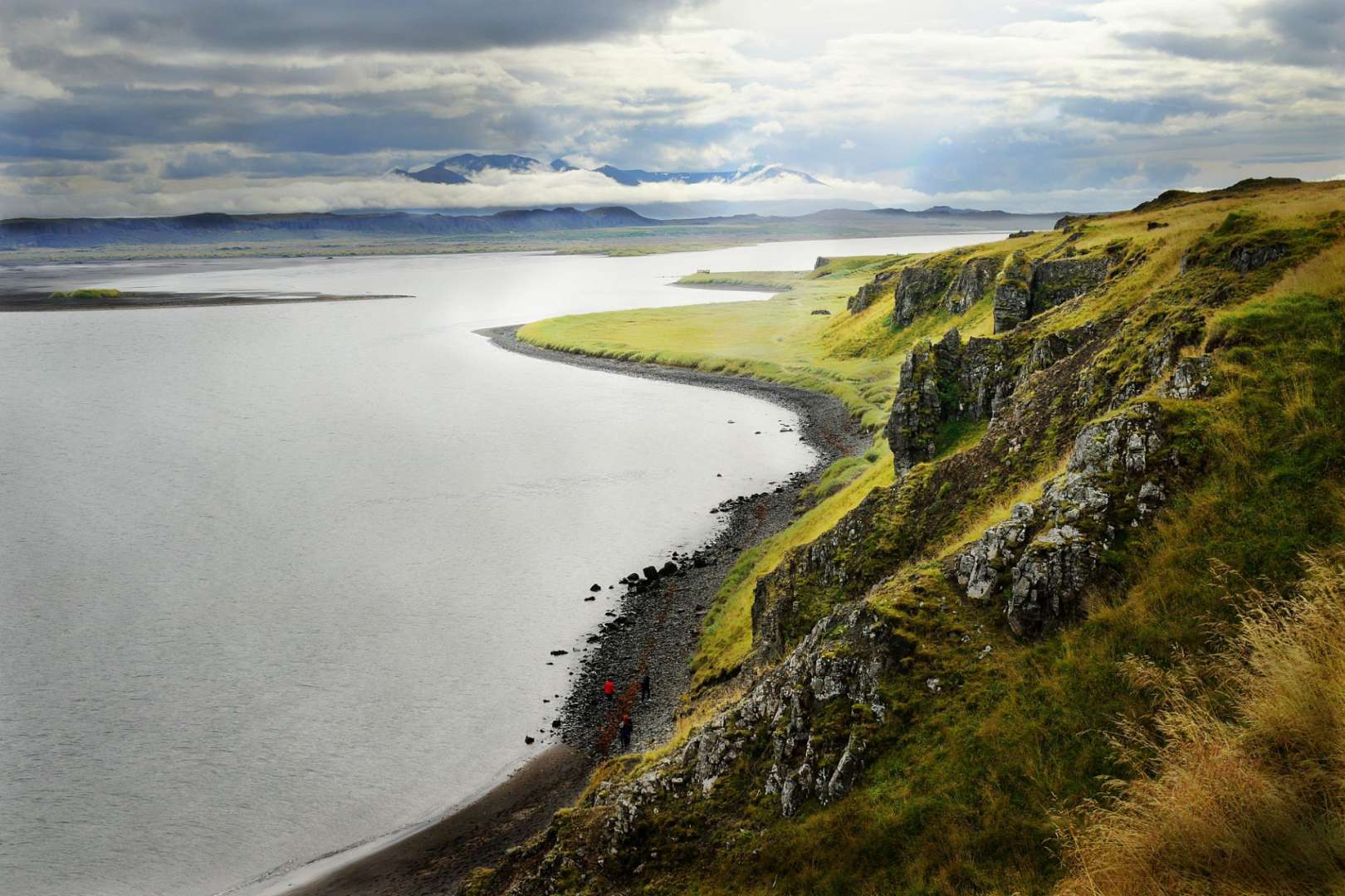 Ein Fluss fließt durch eine Landschaft mit Bergen im Hintergrund