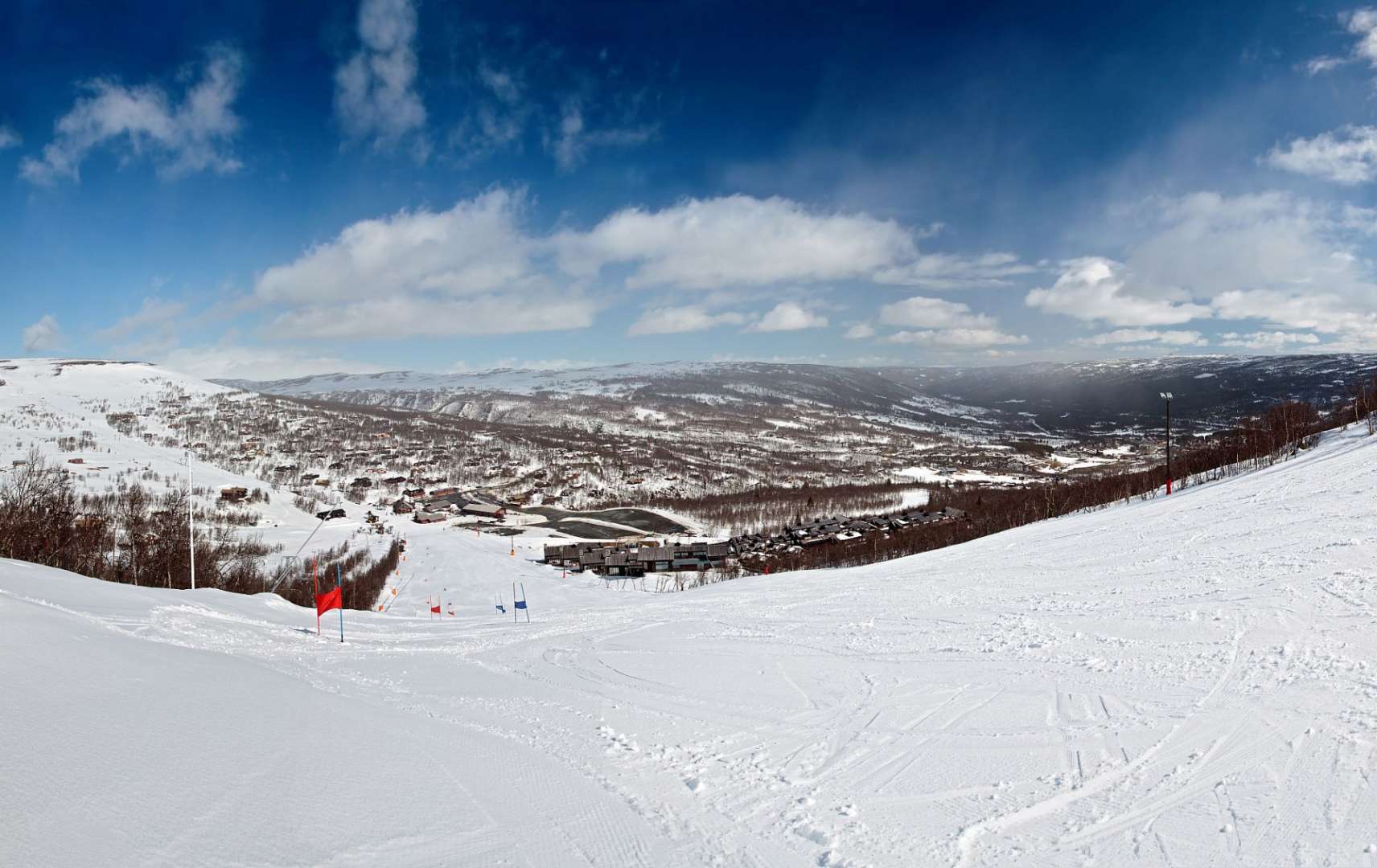 Ein schneebedeckter Berghang mit einer Stadt im Hintergrund