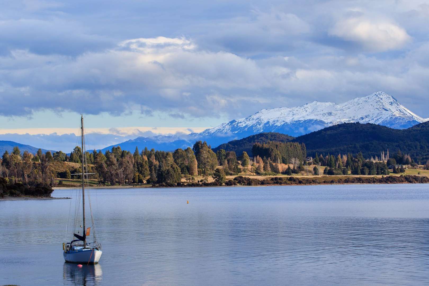 Ein Boot schwimmt in einem See mit Bergen im Hintergrund