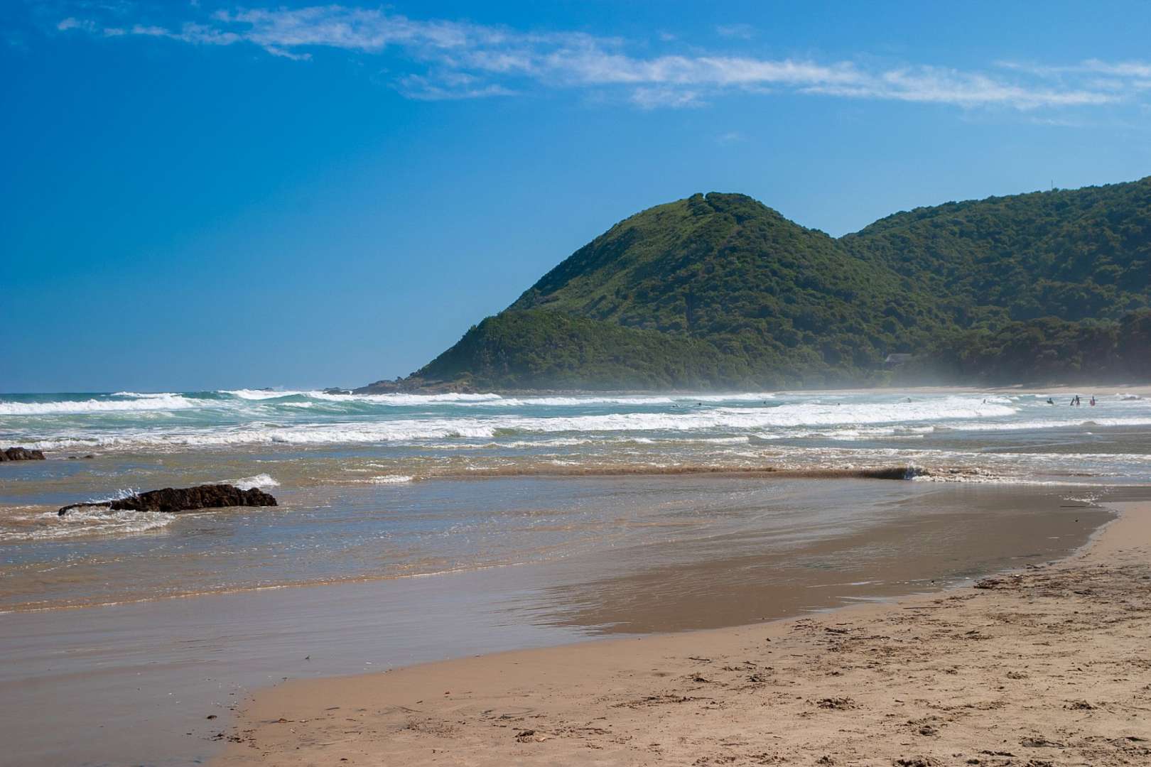 Ein Strand mit einem großen Berg im Hintergrund