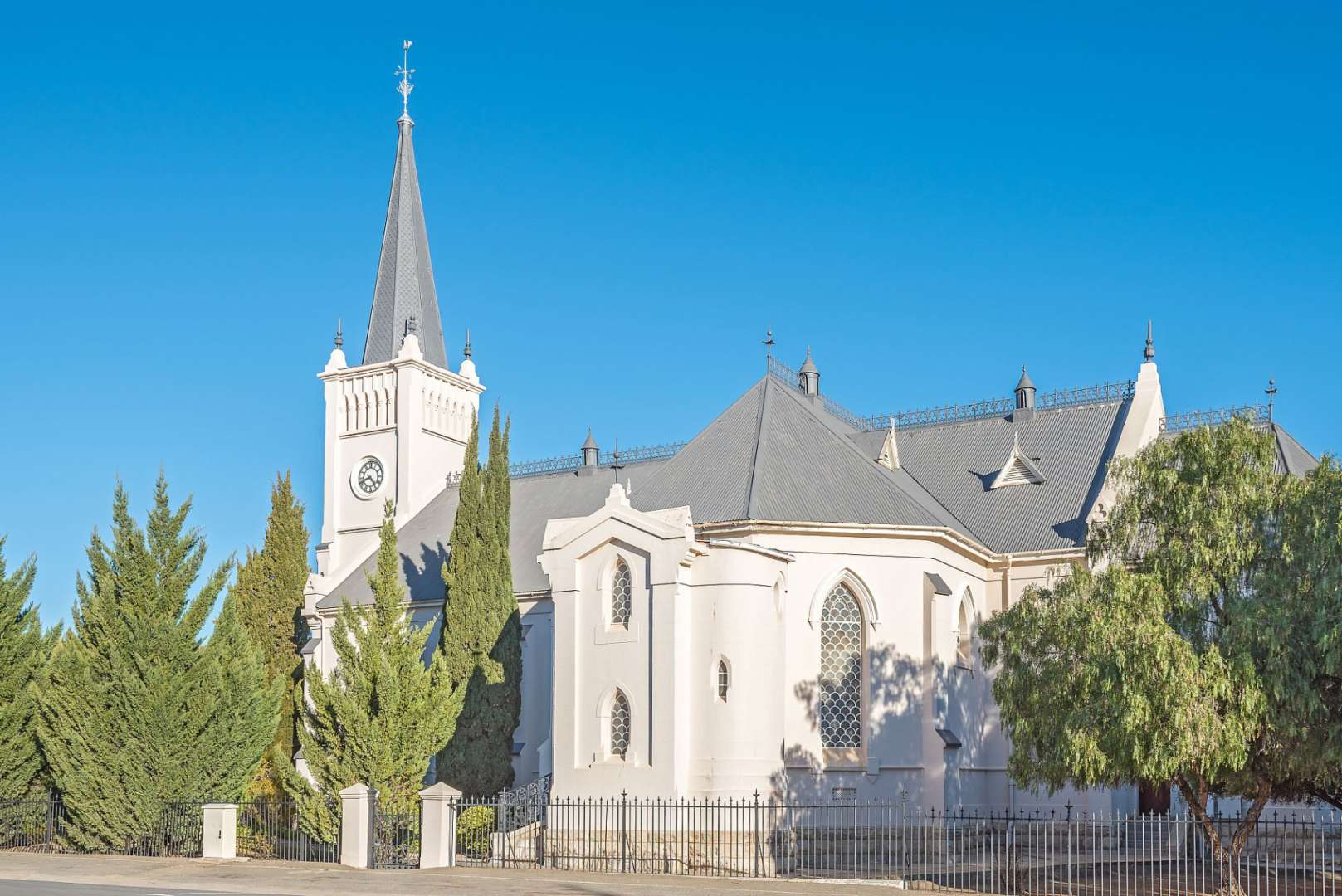 Eine weiße Kirche mit einem schwarzen Turm und einem Uhrturm