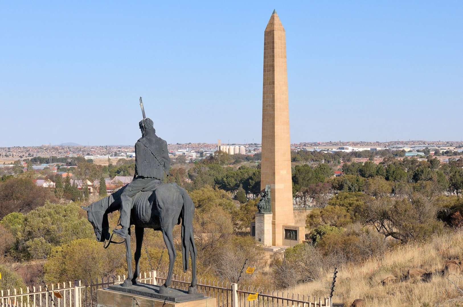 Eine Statue eines Mannes auf einem Pferd neben einem Obelisk