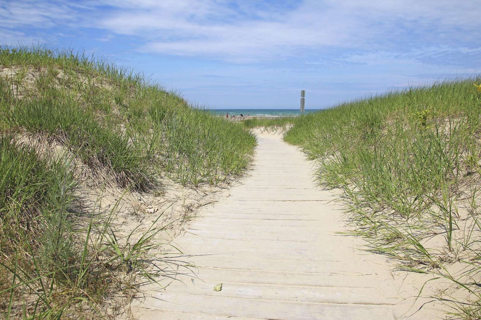 Ein Holzweg führt durch Sanddünen zum Strand