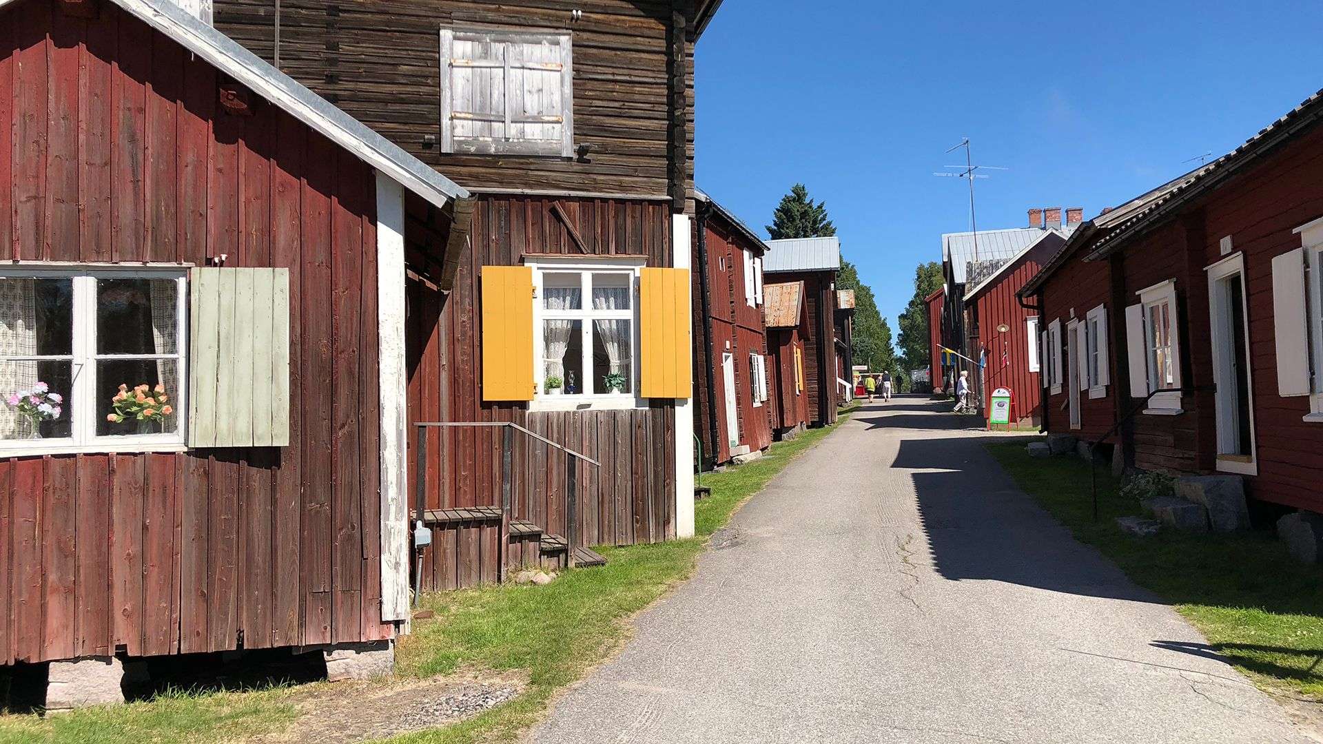 Eine Straße mit roten Häusern und weißen Fensterläden